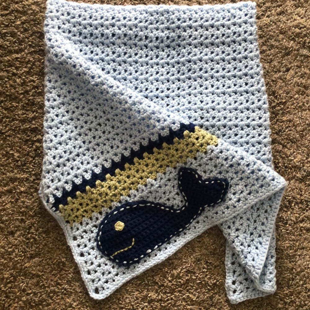 Hand made afghan/baby blanket. Blues and greens. With a whale on the bottom.